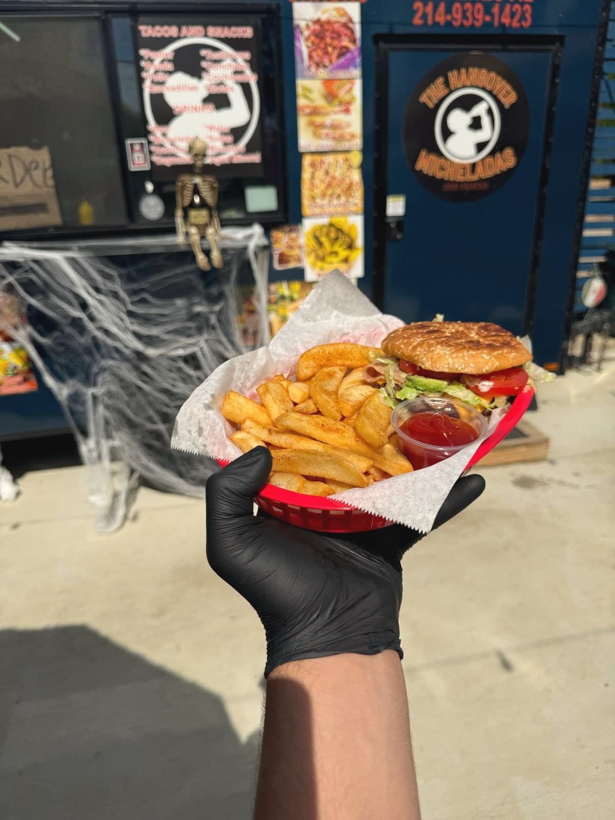 Gloved hand holding a burger basket in front of the trailer