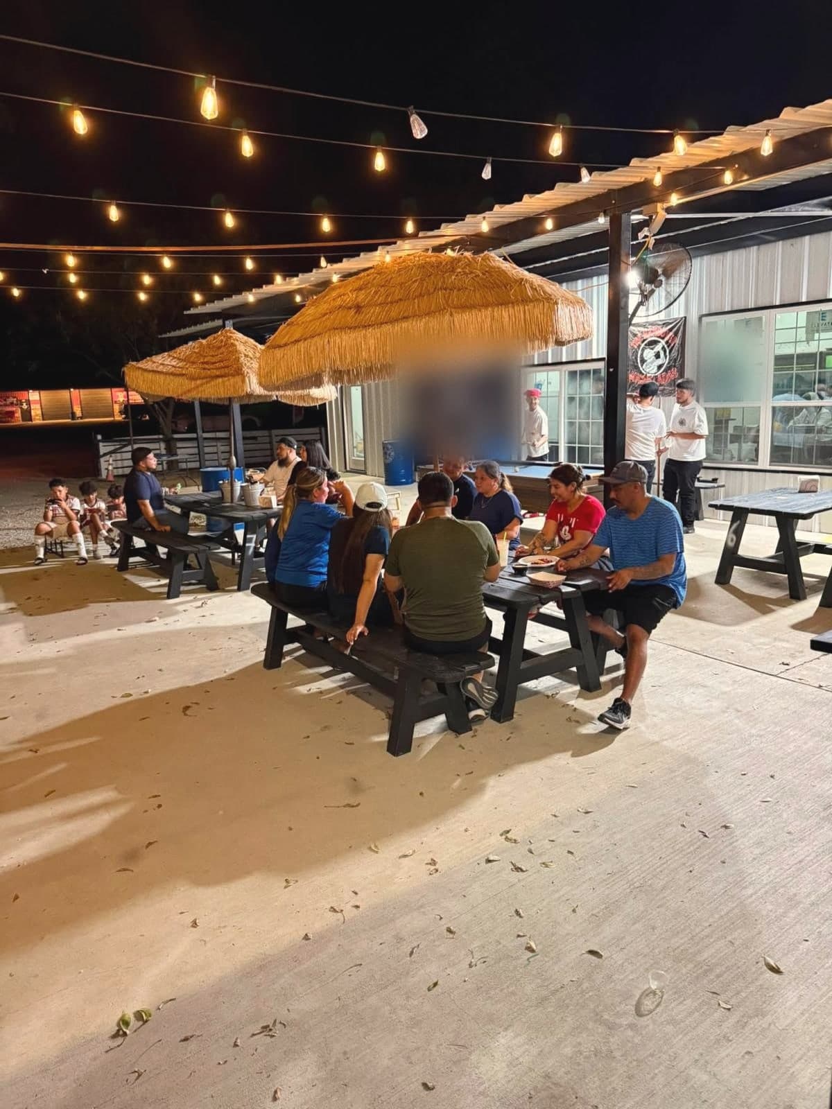Families eating under the patio lights